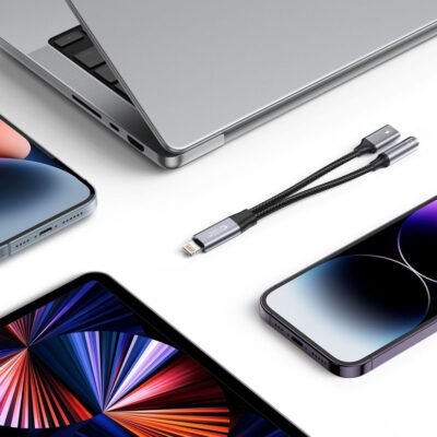 Juodas adapteris TECH-PROTECT ULTRABOOST LIGHTNING TO MINI JACK 3.5MM & LIGHTNING su dviem jungtimis ant balto fono tarp išmaniųjų įrenginių