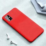 Raudonas silikoninis dėklas Samsung Galaxy A715 A71 Liquid Silicone 1.5mm ant telefono stalo šalia ausinių