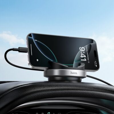 Juodas Hoco H100 automobilinis telefono laikiklis pritvirtintas prie automobilio skydelio, laikantis išmanųjį telefoną.